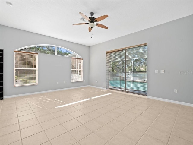 tiled empty room featuring ceiling fan