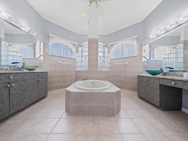 bathroom with tile patterned floors, tile walls, and a healthy amount of sunlight