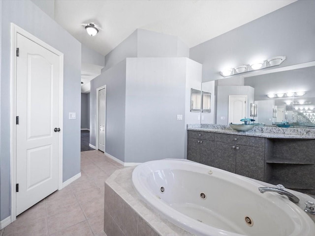 bathroom featuring tile patterned floors, vanity, and a relaxing tiled tub