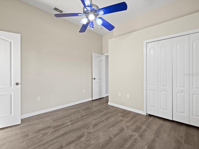 unfurnished bedroom featuring ceiling fan, a closet, and wood-type flooring