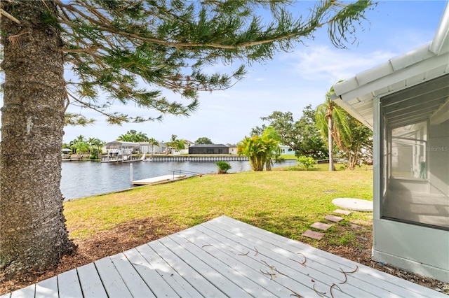 wooden terrace with a yard and a water view