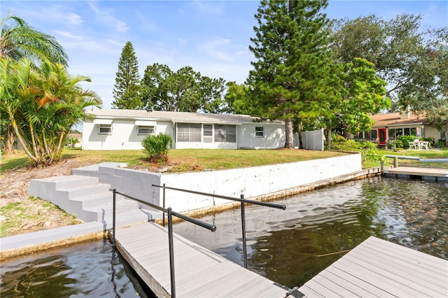 dock area with a lawn and a water view