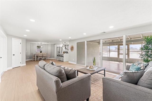 living room featuring light hardwood / wood-style floors and a water view