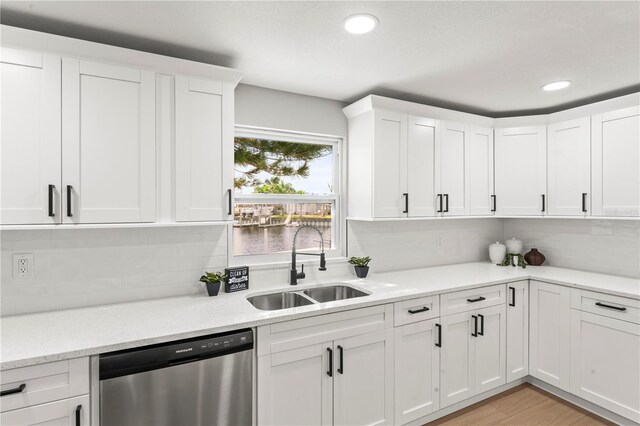 kitchen featuring backsplash, sink, white cabinets, and stainless steel dishwasher