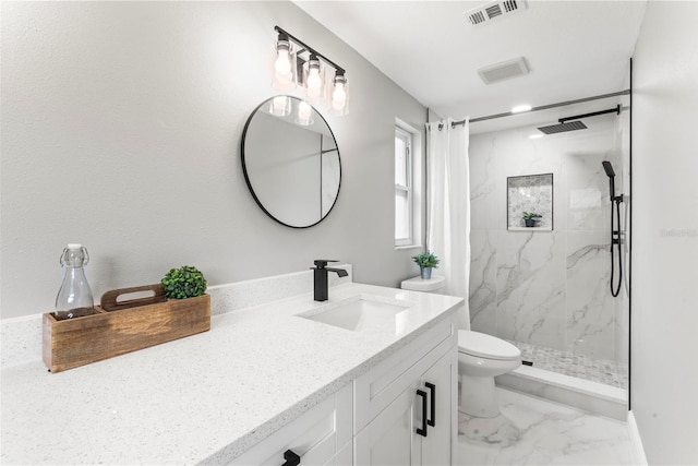 bathroom with vanity, toilet, and tiled shower