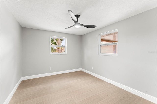 empty room with ceiling fan, light hardwood / wood-style flooring, and a textured ceiling