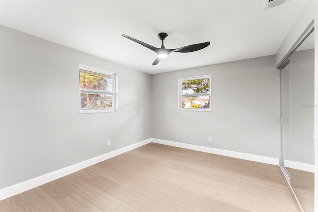 unfurnished bedroom with ceiling fan, light wood-type flooring, and a closet