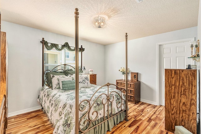 bedroom featuring light hardwood / wood-style floors and a textured ceiling