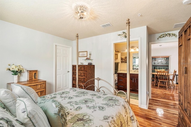 bedroom featuring a textured ceiling and light hardwood / wood-style floors