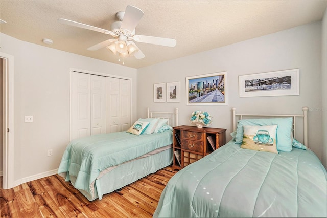 bedroom featuring wood-type flooring, a textured ceiling, a closet, and ceiling fan