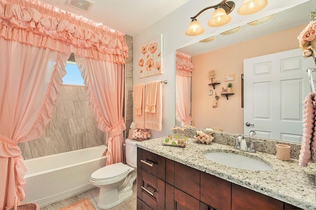 full bathroom with shower / bath combo with shower curtain, vanity, a textured ceiling, and toilet