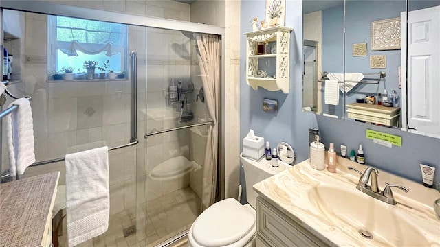 bathroom featuring a shower with door, vanity, and toilet