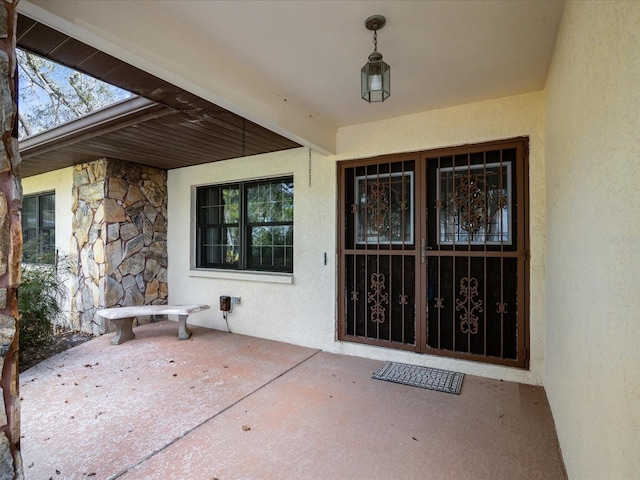 view of exterior entry featuring a patio