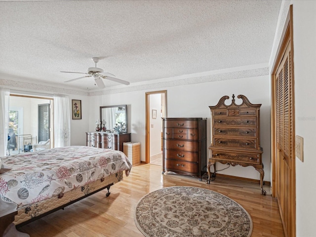 bedroom with ceiling fan, a closet, a textured ceiling, and light hardwood / wood-style flooring