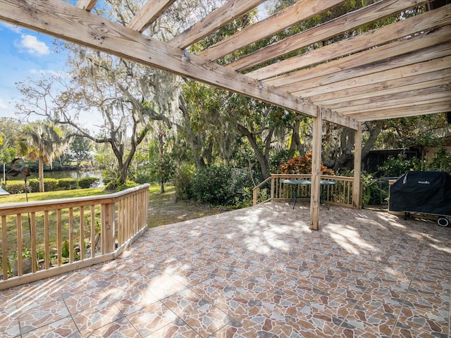 view of patio with a pergola, grilling area, and a water view