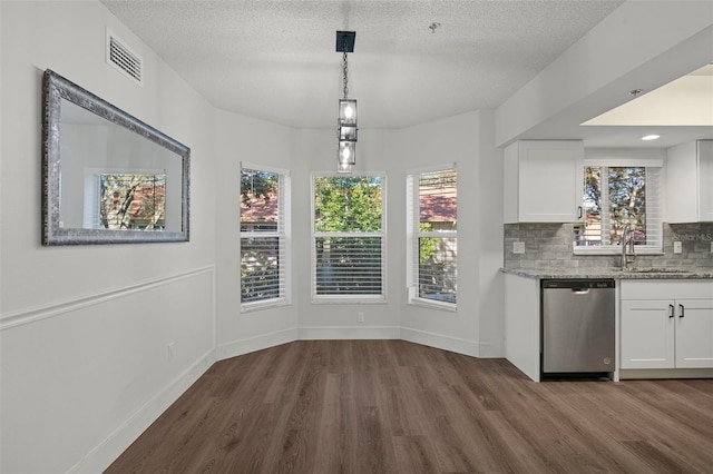 unfurnished dining area featuring a textured ceiling, dark wood-type flooring, and sink