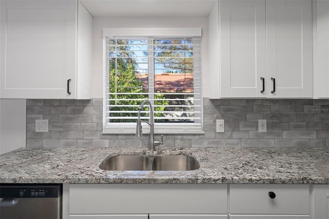 kitchen with sink, stainless steel dishwasher, white cabinets, and light stone counters