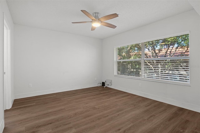 spare room with ceiling fan, a textured ceiling, and dark hardwood / wood-style flooring