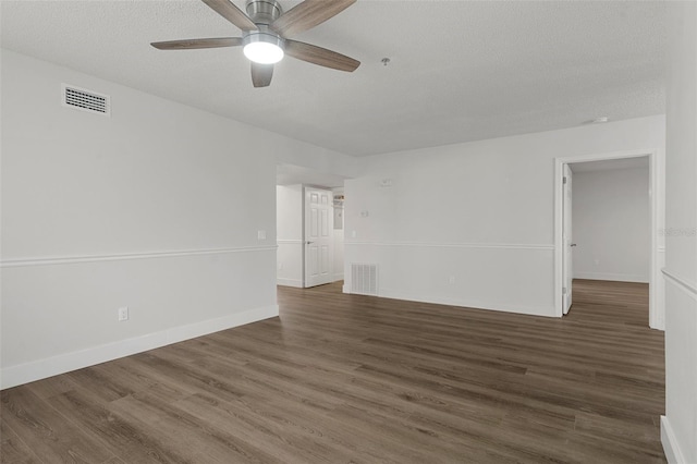 empty room featuring dark hardwood / wood-style flooring, ceiling fan, and a textured ceiling