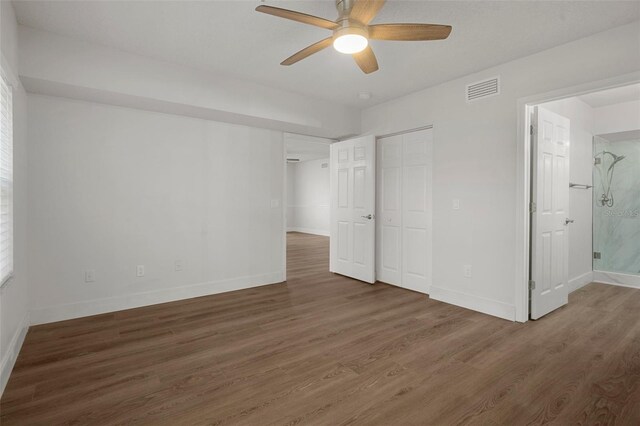 unfurnished bedroom featuring ceiling fan, connected bathroom, and dark hardwood / wood-style floors