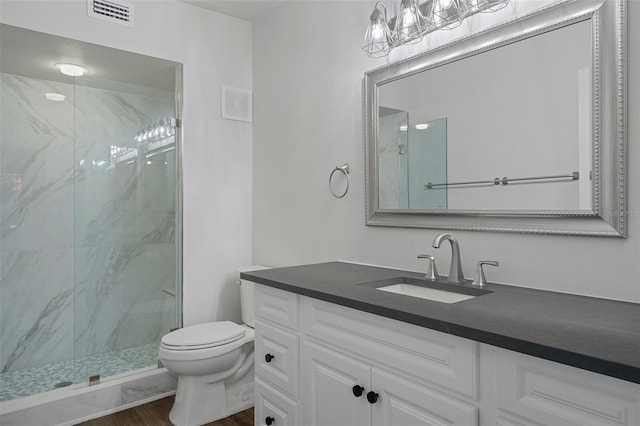 bathroom featuring vanity, tiled shower, toilet, and hardwood / wood-style floors