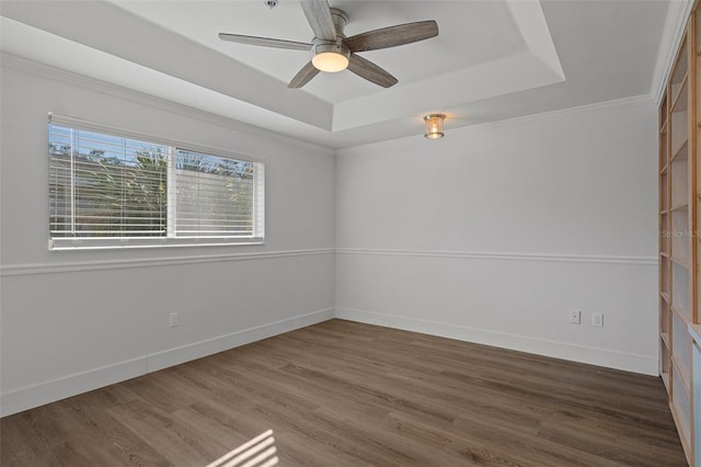 spare room with ceiling fan, crown molding, a raised ceiling, and dark hardwood / wood-style floors