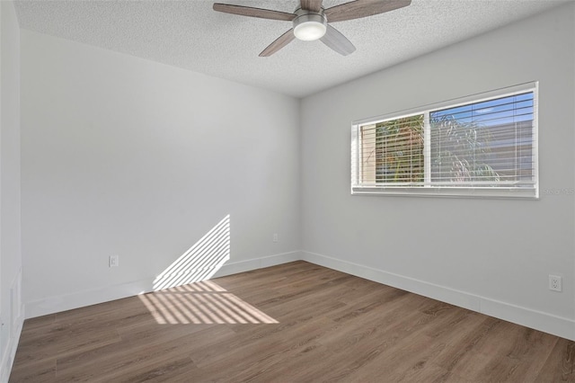 spare room with ceiling fan, wood-type flooring, and a textured ceiling