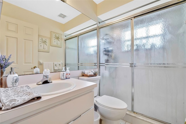 bathroom featuring vanity, a shower with shower door, and toilet