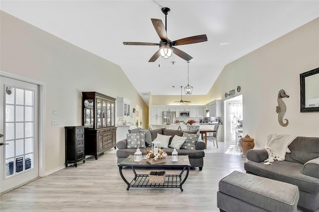 living room featuring light hardwood / wood-style floors, ceiling fan, and lofted ceiling