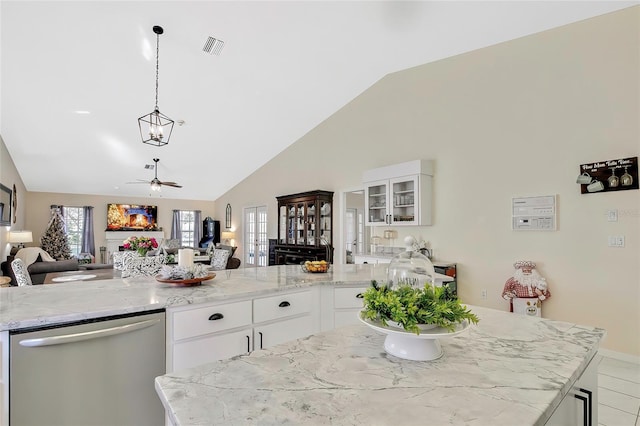 kitchen with a wealth of natural light, white cabinetry, ceiling fan, and stainless steel dishwasher