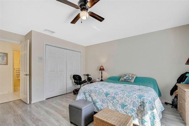 bedroom with ceiling fan, a closet, and light wood-type flooring