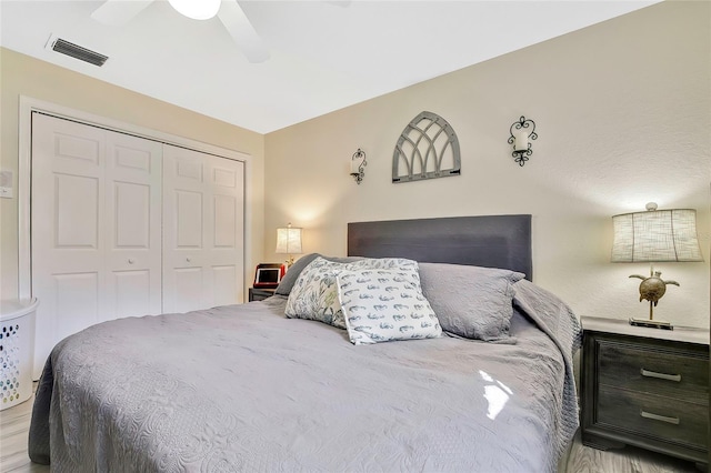 bedroom with a closet, light hardwood / wood-style flooring, and ceiling fan