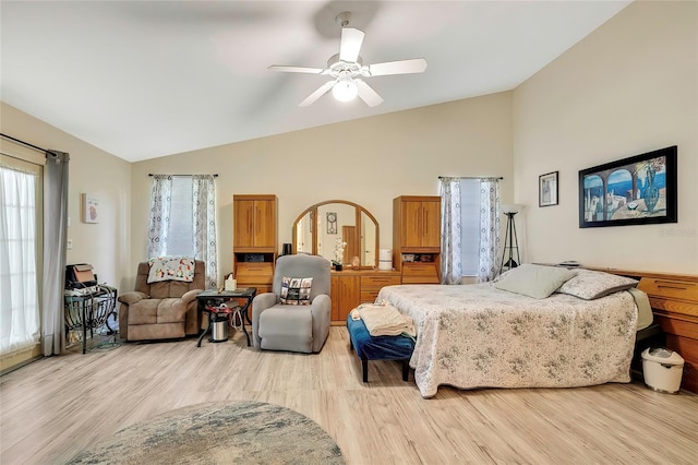 bedroom with ceiling fan, light hardwood / wood-style floors, and vaulted ceiling