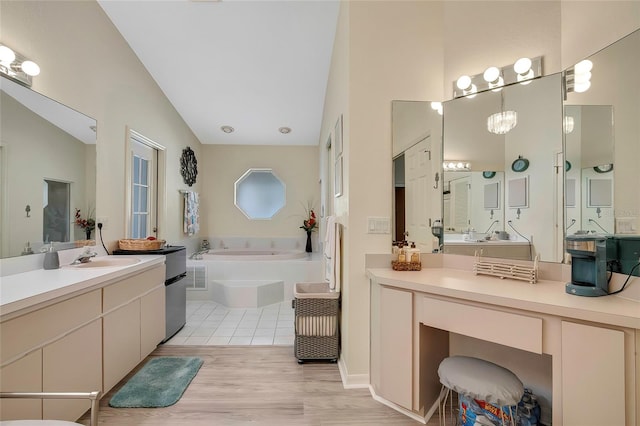 bathroom with hardwood / wood-style floors, vanity, lofted ceiling, and tiled bath