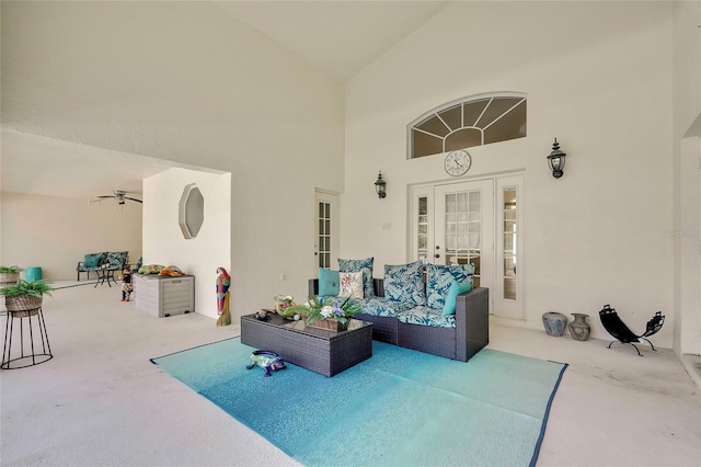 carpeted living room featuring ceiling fan, french doors, and high vaulted ceiling