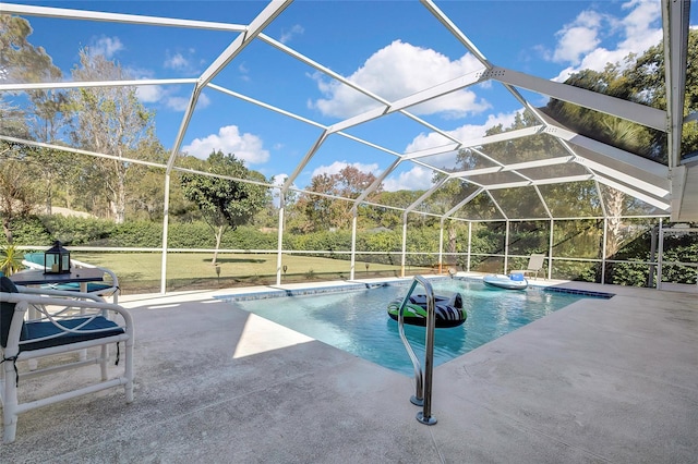 view of pool with glass enclosure, a yard, and a patio