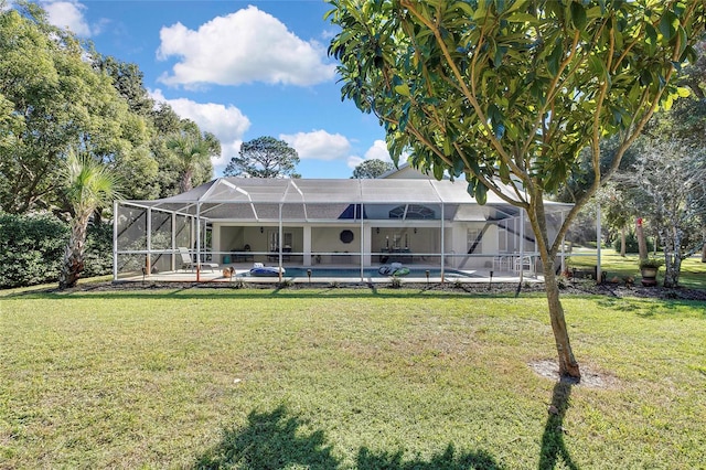 rear view of property featuring a lanai and a lawn