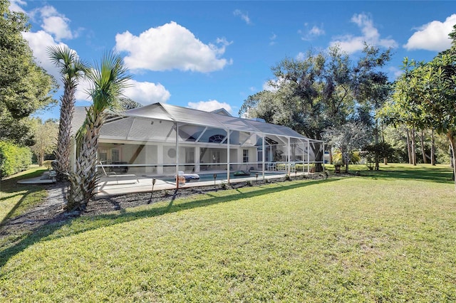 rear view of house featuring a lanai, a patio area, and a lawn