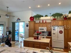 kitchen featuring white appliances, a kitchen island, and ceiling fan