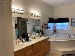 bathroom with vanity and a tub to relax in