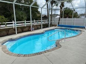 view of pool with a patio and glass enclosure