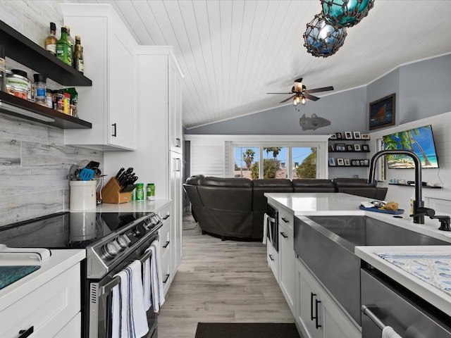 kitchen with ceiling fan, light hardwood / wood-style flooring, white cabinets, lofted ceiling, and stainless steel electric range