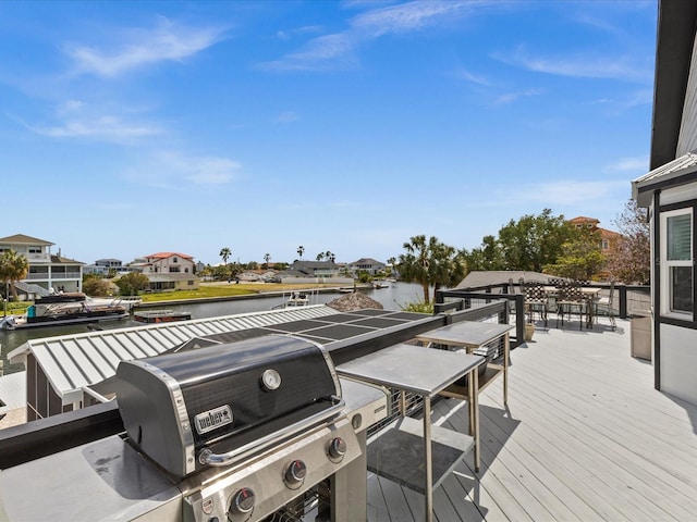 wooden terrace with a water view and area for grilling