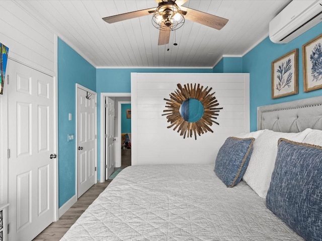 bedroom with wood-type flooring, wood ceiling, a wall mounted AC, and ceiling fan