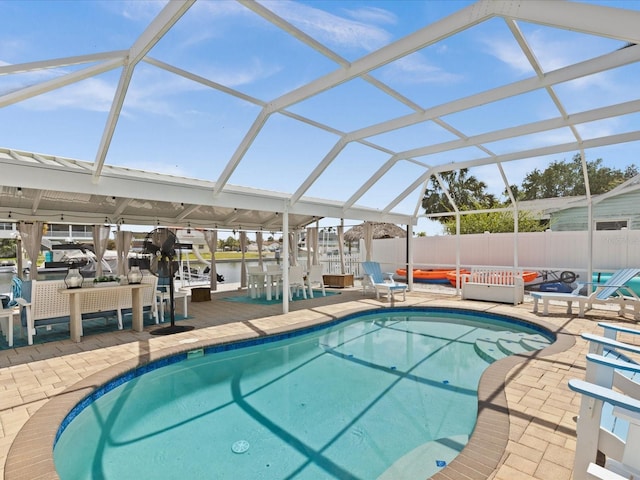 view of swimming pool with a lanai, a water view, and a patio