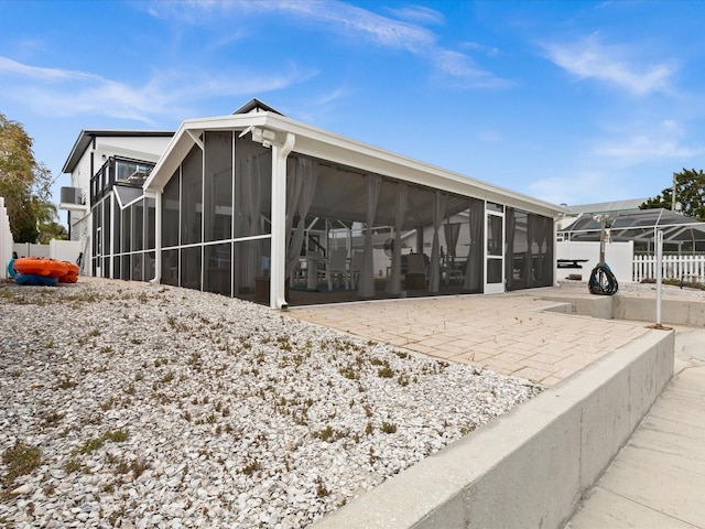 view of property exterior featuring a patio area and a sunroom