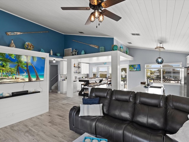 living room with ceiling fan, plenty of natural light, lofted ceiling, and light hardwood / wood-style flooring