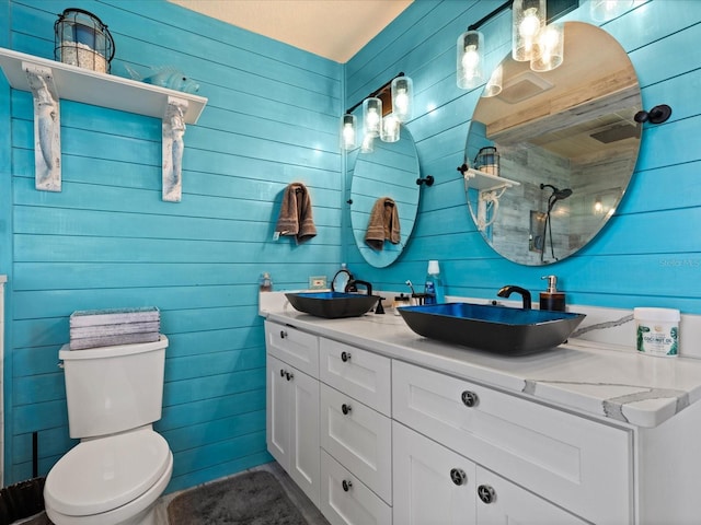 bathroom with walk in shower, wooden walls, vanity, and toilet