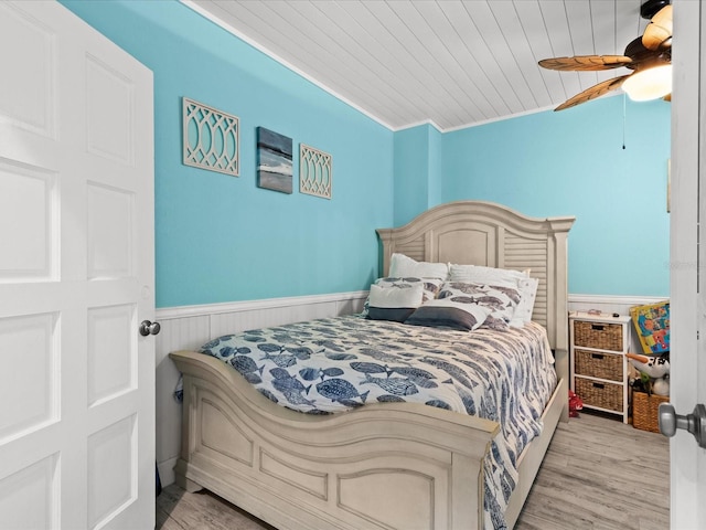 bedroom with light wood-type flooring, wooden ceiling, ceiling fan, and ornamental molding