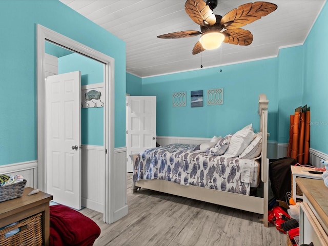 bedroom featuring light hardwood / wood-style floors, ceiling fan, and ornamental molding